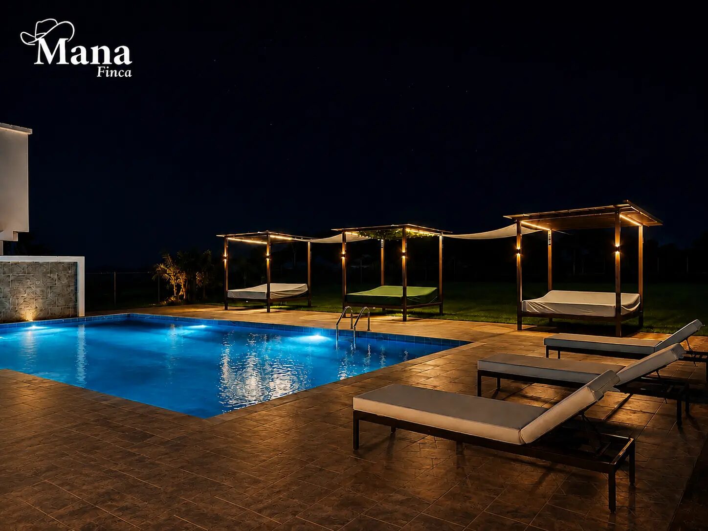 Zona de piscina de Finca Mana iluminada al anochecer